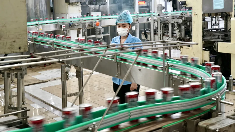 Công nhân giám sát dây chuyền sản xuất tại Công ty TNHH SX-TM Tân Quang Minh - BIDRICO, Khu công nghiệp Vĩnh Lộc, huyện Bình Chánh, TPHCM. Ảnh: HOÀNG HÙNG