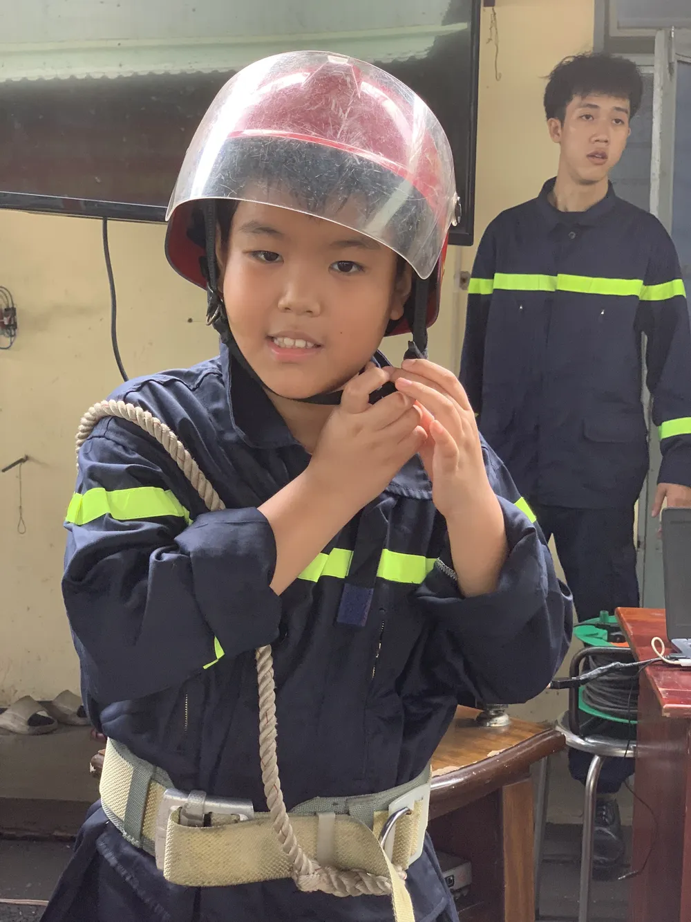 Học sinh được hướng dẫn mặc trang phục của chiến sĩ Phòng cháy chữa cháy