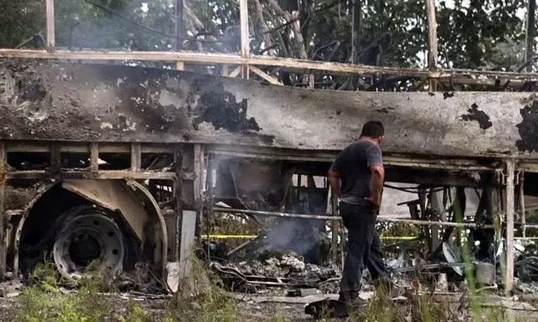 Hiện trường chiếc xe khách bị thiêu rụi sau khi va chạm với một xe đầu kéo trong hành trình từ Cancun đến Tabasco. Ảnh: REUTERS