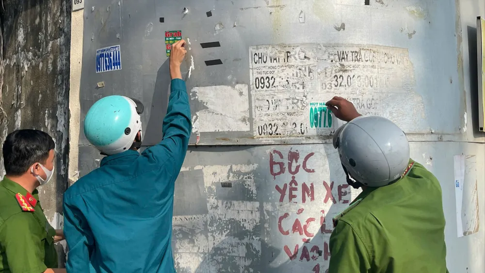 Lực lượng chức năng bóc gỡ quảng cáo bẩn 