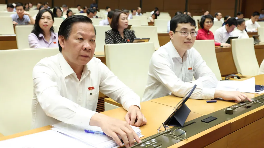 Đại biểu Quốc hội bấm nút biểu quyết thông qua luật, chiều 18-6. Ảnh: QUANG PHÚC