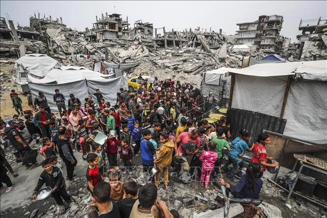 Người dân Palestine chờ được phát thực phẩm cứu trợ tại Gaza. Ảnh: THX/TTXVN