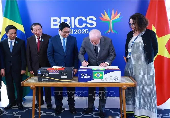 Tổng thống Cộng hòa Liên bang Brazil Lula da Silva ký vào thùng hàng tượng trưng lô hàng thịt bò đầu tiên của Brazil xuất sang Việt Nam. Ảnh: TTXVN