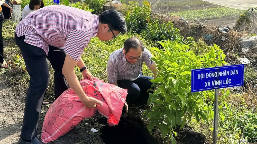 Bí thư Đảng ủy xã Vĩnh Lộc Huỳnh Cao Cường đang trồng cây hưởng ứng lễ phát động thi đua. Ảnh: THANH HIỀN