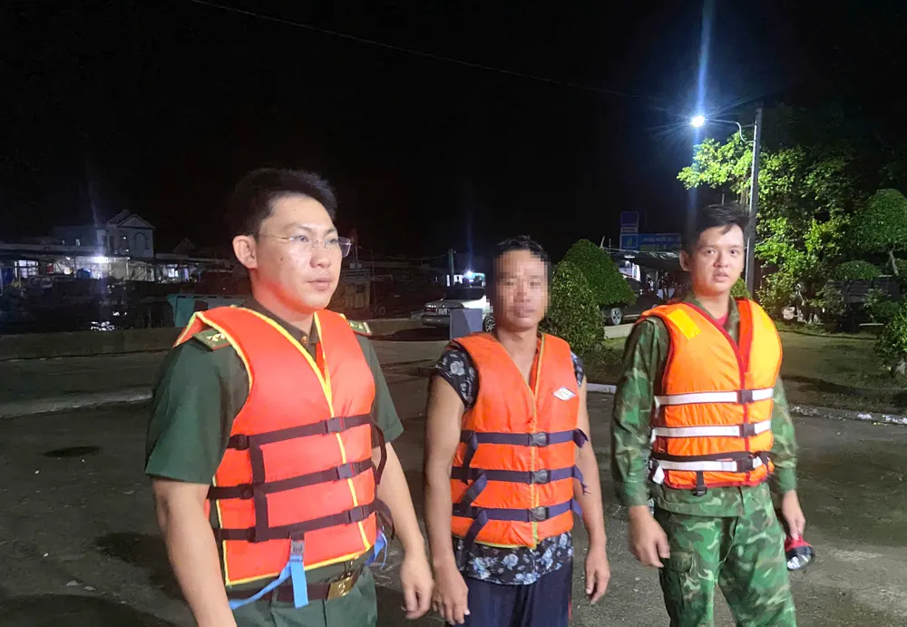 Đồn Biên phòng Khánh Hội cứu vớt và đưa ngư dân (giữa) vào bờ an toàn. Ảnh: HOÀNG TÁ