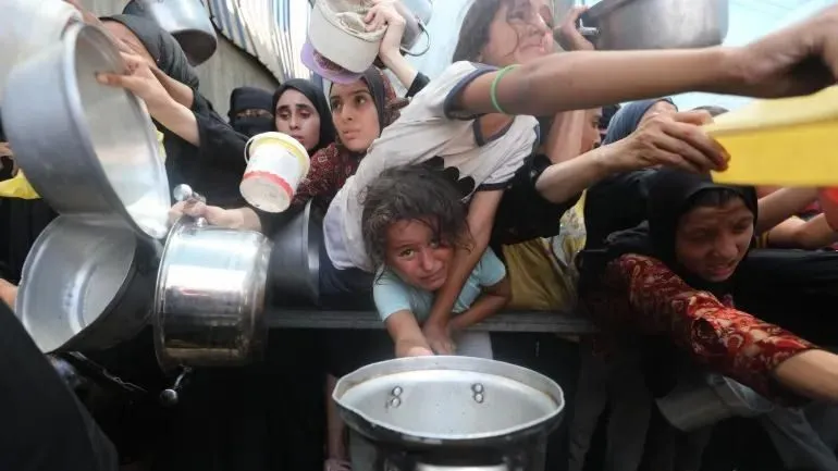 Người dân Palestine nhận thực phẩm do một tổ chức từ thiện phân phát tại trại tị nạn Nuseirat. Ảnh: ANADOLU AGENCY