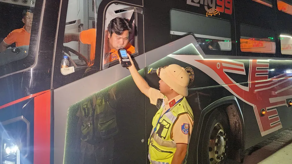 Lực lượng cảnh sát giao thông kiểm tra nồng độ cồn đối với tài xế xe kinh doanh vận tải. Ảnh: VĂN HUẾ