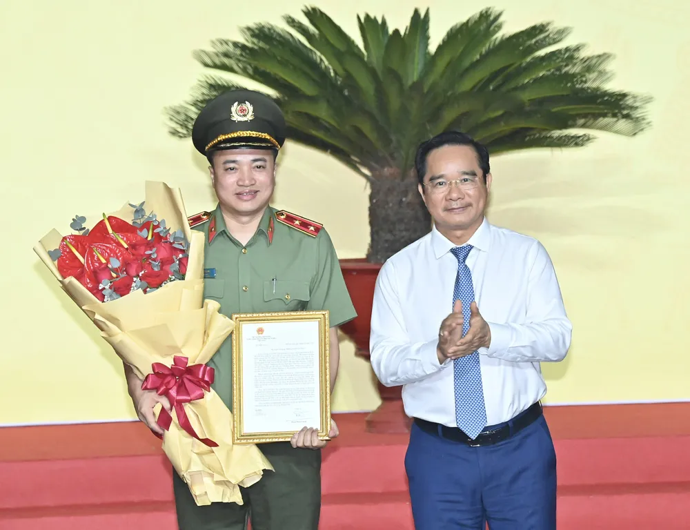 Chủ tịch UBND TPHCM Nguyễn Văn Được trao thư khen của Thủ tướng Chính phủ cho Trung tướng Mai Hoàng. Ảnh: VIỆT DŨNG