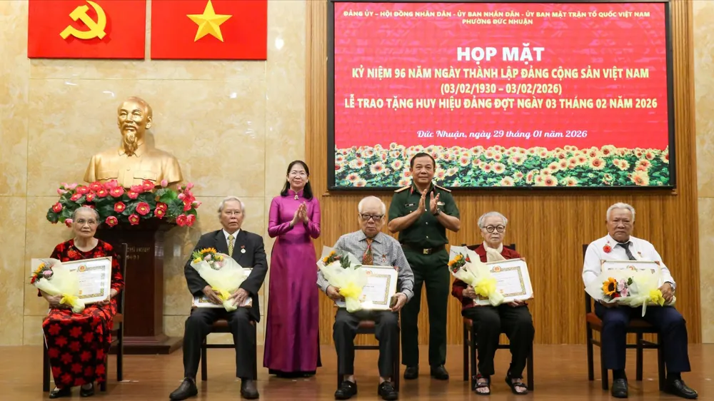 Thiếu tướng Vũ Văn Điền và đồng chí Phan Thị Thanh Phương trao Huy hiệu Đảng đến các đảng viên