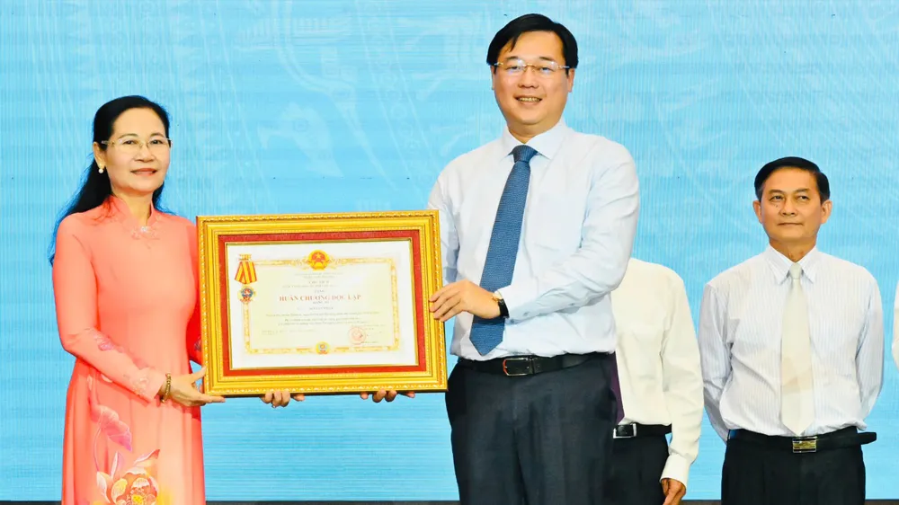 Phó Bí thư Thường trực Thành ủy TPHCM Lê Quốc Phong trao Huân chương Độc lập hạng ba đến đồng chí Nguyễn Thị Lệ, nguyên Phó Bí thư Thành ủy, nguyên Chủ tịch HĐND TPHCM. Ảnh: VIỆT DŨNG