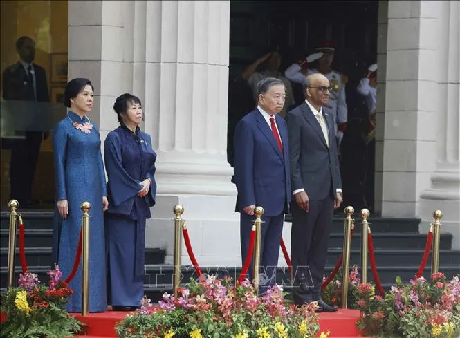 Tổng Bí thư, Chủ tịch nước Tô Lâm và Tổng thống Singapore Tharman Shanmugaratnam trên bục danh dự, nghe Quân nhạc cử Quốc thiều hai nước. Ảnh: TTXVN