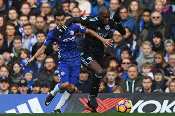 Pedro (trái, Chelsea) tranh bóng với Allan Nyom ( West Brom).
