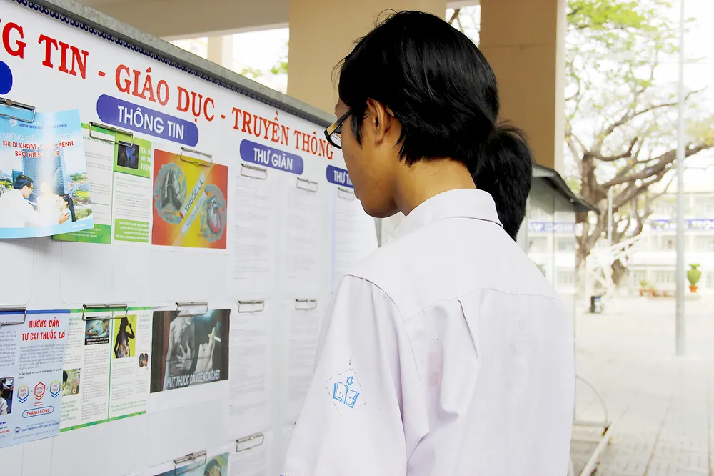 Học sinh tìm hiểu cách phòng chống tác hại thuốc lá tại bảng tuyên truyền 	Ảnh: NGÔ ĐỒNG