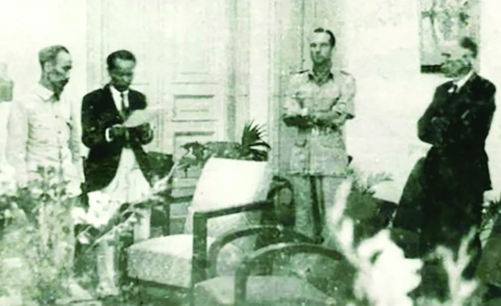 Chủ tịch Hồ Chí Minh ký Hiệp ước sơ bộ ngày 6-3-1946 với đại diện Chính phủ Pháp Sainteny ở số 4 phố Lê Lai - Hà Nội; Thứ trưởng Ngoại giao Hoàng Minh Giám đang đọc bản hiệp ước.  Ảnh: Nguyễn Bá Khoản