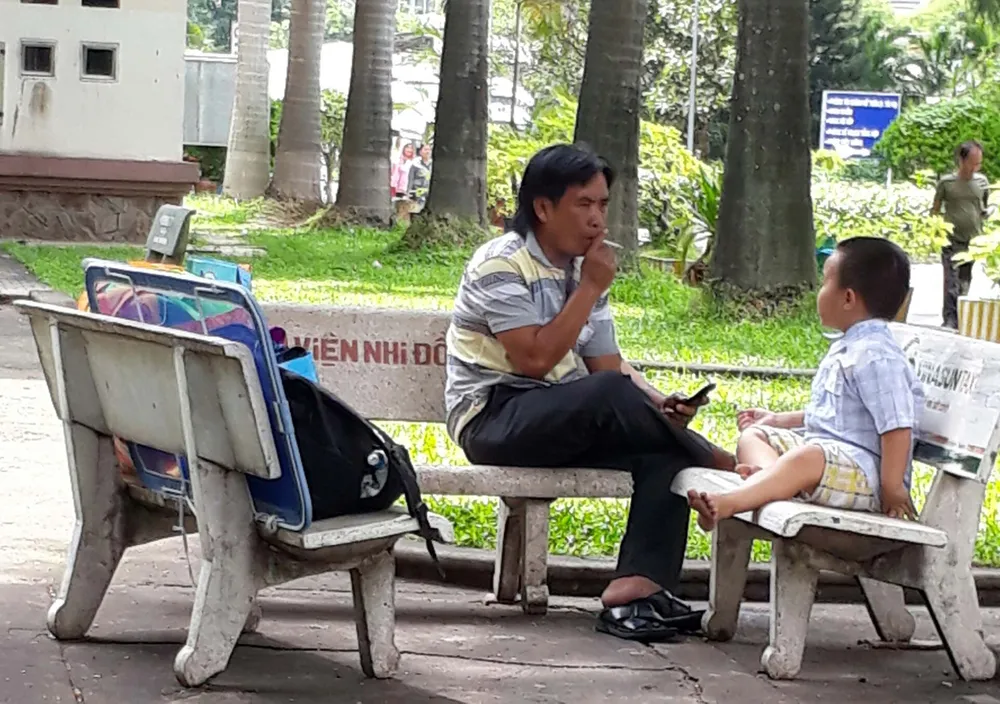       Cảnh thản nhiên hút thuốc ngay trong Bệnh viện Nhi đồng 2              . Ảnh: THU HƯỜNG