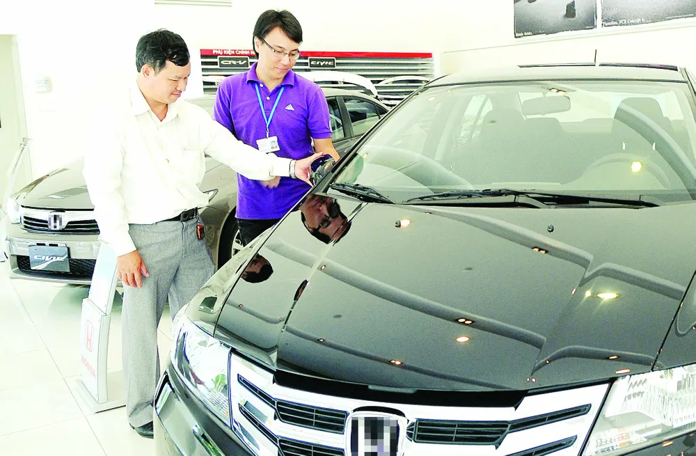 Khách tham quan một salon ô tô  ở TPHCM. Ảnh:  CAO THĂNG