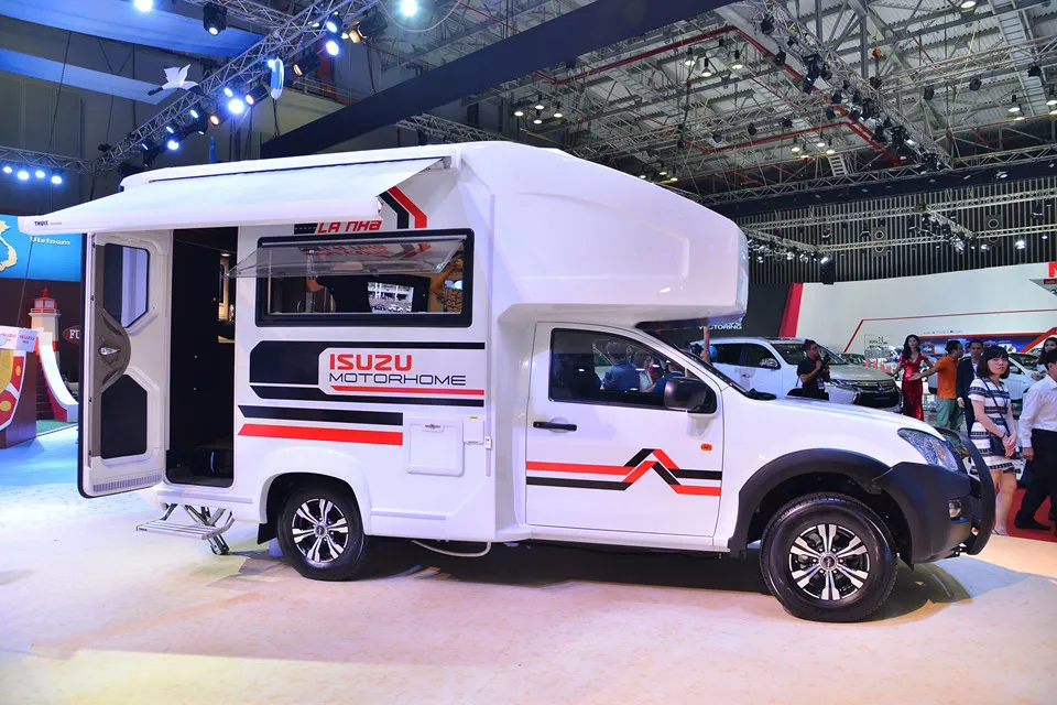 Gian hàng Isuzu gây chú ý với khách tham quan bằng mẫu MotorHome. Chiếc xe được cải tạo từ mẫu bán tải D-Max với khoang sau đầy đủ tiện nghi, phục vụ cho nhu cầu thư giãn, giải trí hay đi chơi dài ngày. Phần mái che bên ngoài hoạt động theo cơ cấu cuộn, đáp ứng nhu cầu picnic hay cắm trại ngoài trời. Isuzu MotorHome - 'ngoi nha di dong' la lam tai Viet Nam hinh anh 1