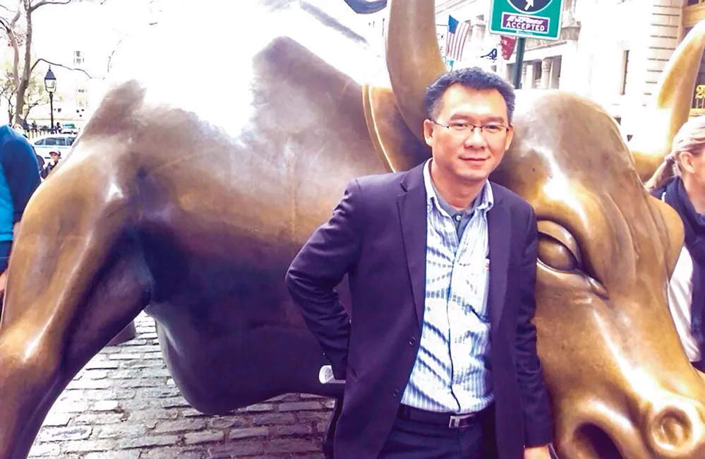 Tác giả bên con tượng con bò trước Sở Giao dịch TTCK New York trong chuyến công tác tại Mỹ năm 2014. 