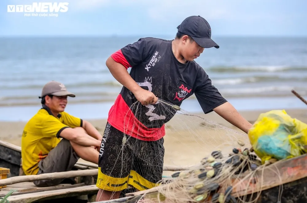 Ngư dân đang tập trung gỡ tôm, cá sau chuyến ra khơi về.
