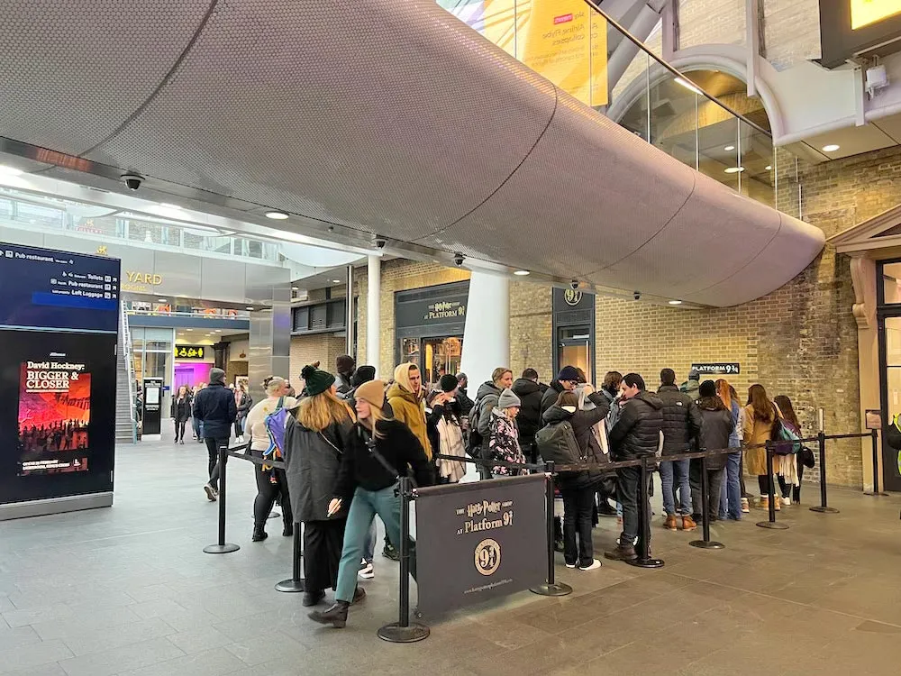Du khách xếp hàng để được chụp ảnh tại khu vực PlatForm Chín- ba phần tư bên cạnh là Harry Potter Shop.