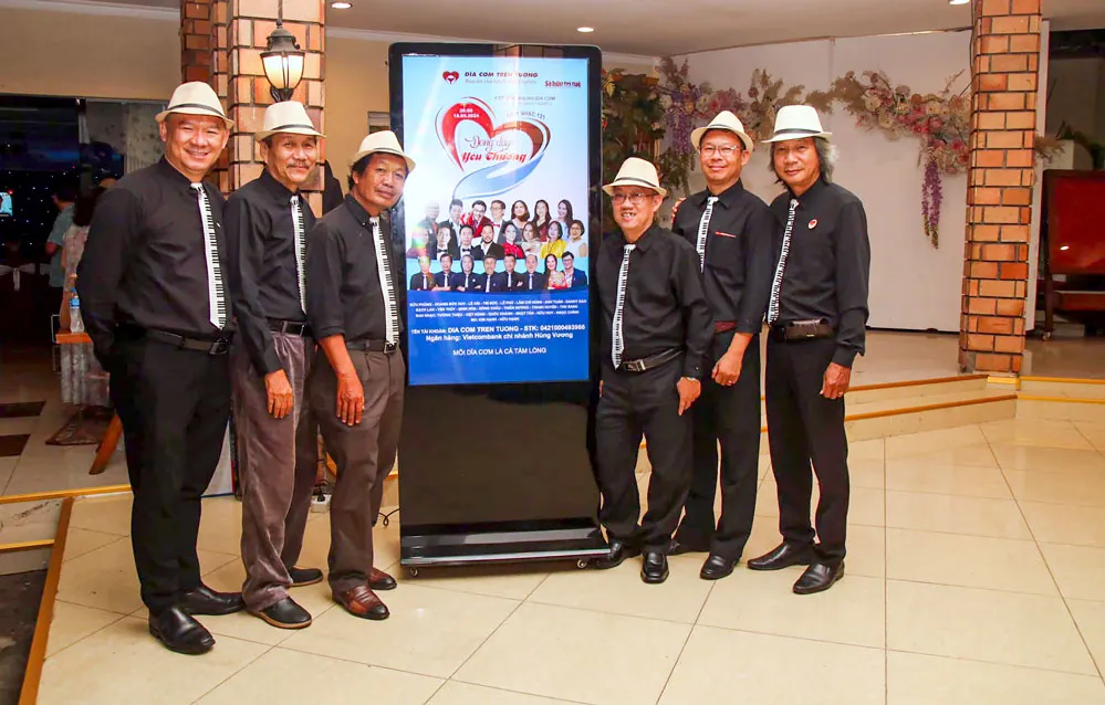 Tác giả (ngoài cùng từ trái sang) chụp ảnh lưu niệm với ban nhạc Đĩa cơm trên tường khi tham gia một chương trình văn nghệ ở quê nhà.