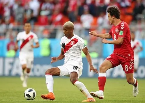 Andre Carrillo (trái, Peru) sutýt tung lưới Đan Mạch.
