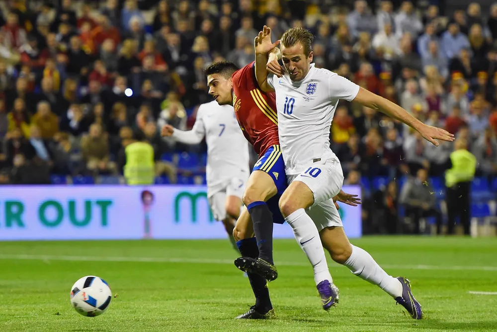 Harry Kane (phải, tuyển Anh) bứt phá qua Marc Bartra (Tây Ban Nha)