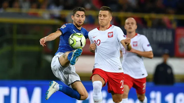Tiền vệ Jorginho (trái, Italia) tranh bóng với Ba Lan