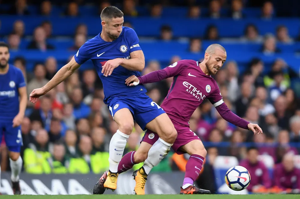 Gary Cahill (trái, Chelsea) tranh bóng với David Silva (Manchester City)