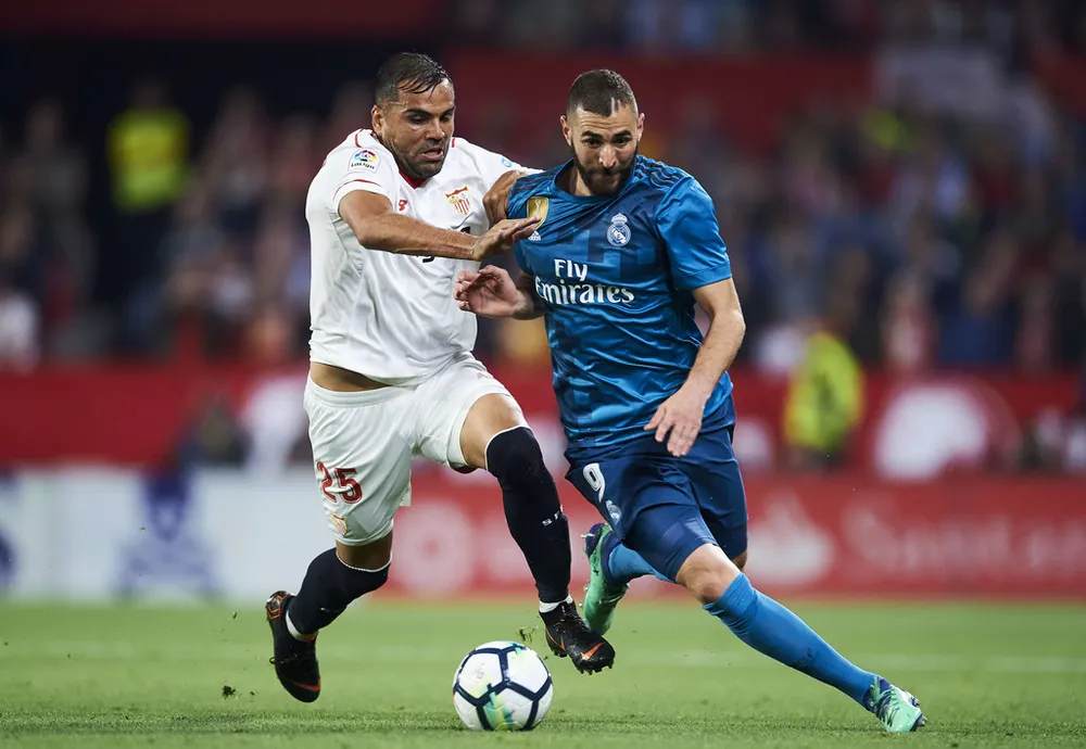 Karim Benzema (phải, Real Madrid) tranh bóng với Gabriel Mercado (Sevilla)