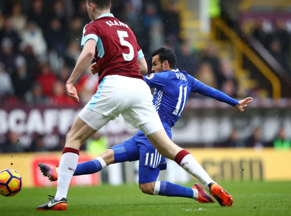 Pedro (Chelsea) sút bóng trước Burnley