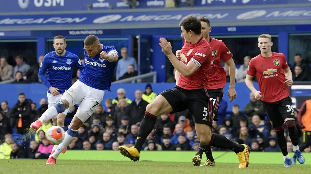 Richarlison sút bóng trước Harry Maguire (Man United)
