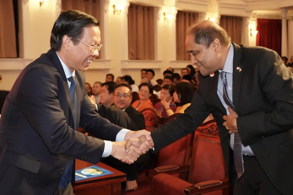 Ông Jaya Ratnam, Đại sứ nước Cộng hòa Singapore tại Việt Nam (phải) và Chủ tịch UBND TPHCM Phan Văn Mãi chúc mừng nhau tại lễ kỷ niệm.Ảnh: HOÀNG HÙNG