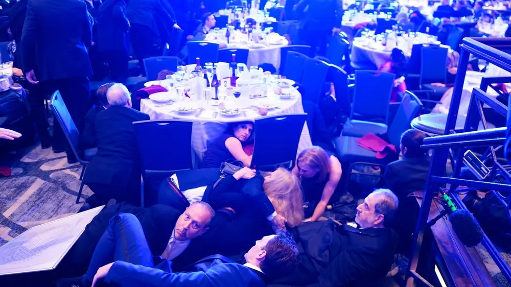 Hình ảnh từ hiện trường cho thấy các khách mời có mặt tại sự kiện tìm chỗ ẩn náu dưới bàn. Ảnh: CNN