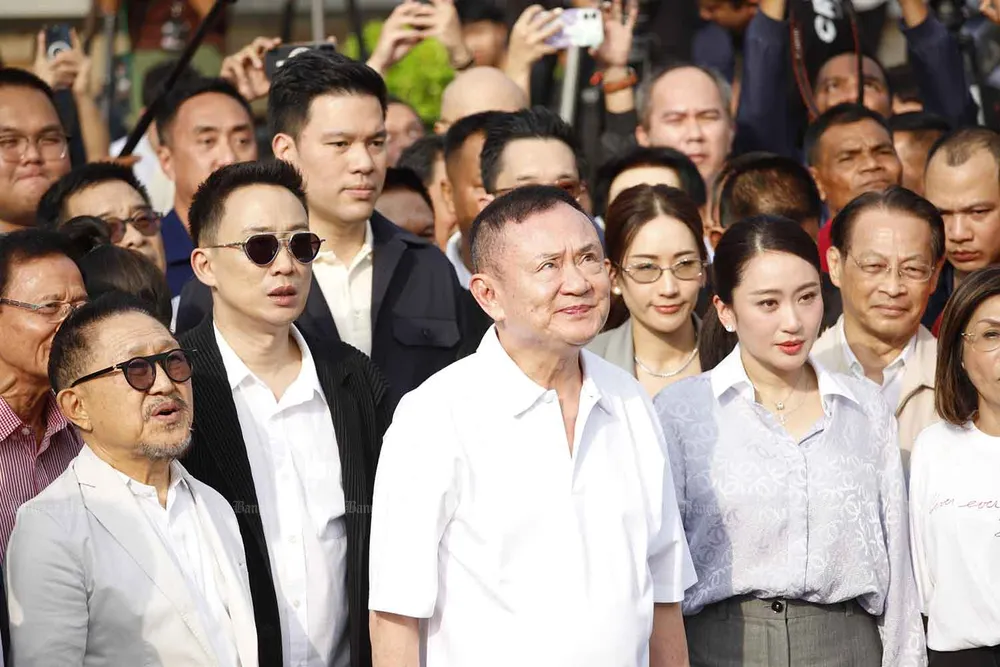 Ông Thaksin đứng im lặng trong khi quốc ca vang lên. Ảnh: BANGKOK POST