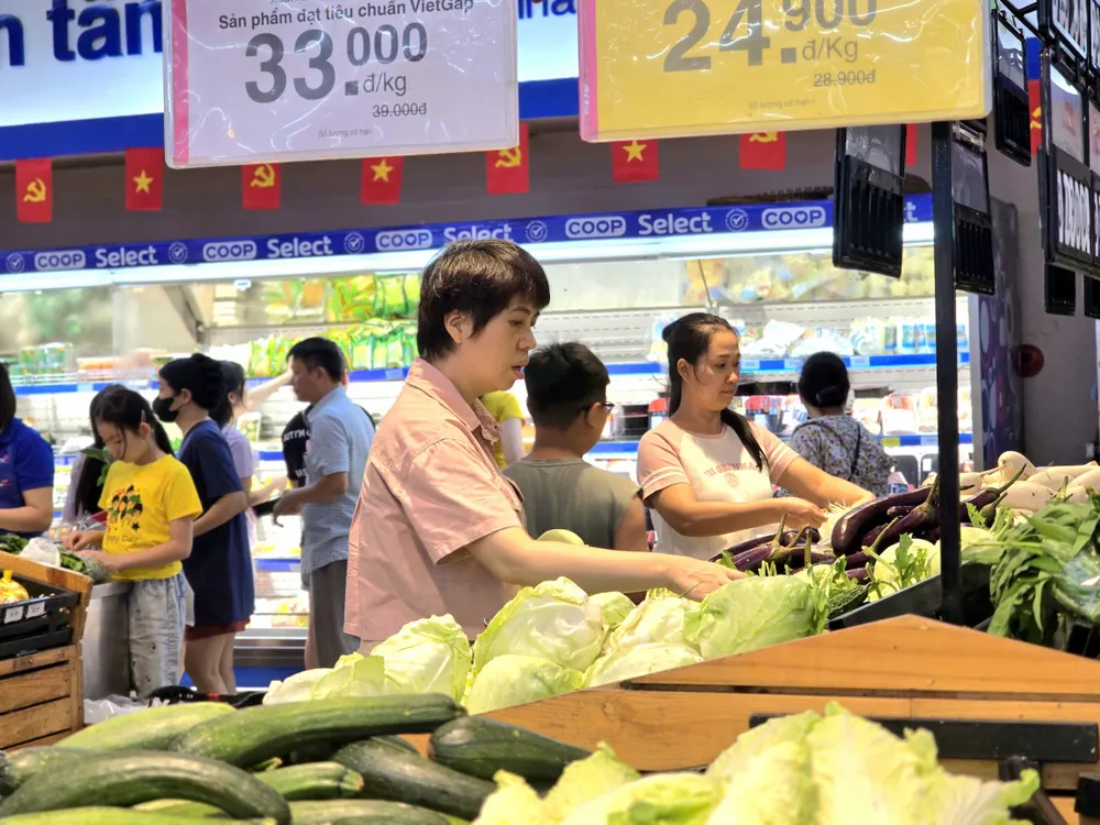 Quầy rau xanh tại hệ thống siêu thị Co.opmart luôn dồi dào, giá cả bình ổn trong cao điểm bão Bualoi, giúp người dân yên tâm dự trữ thực phẩm tươi sống.jpg