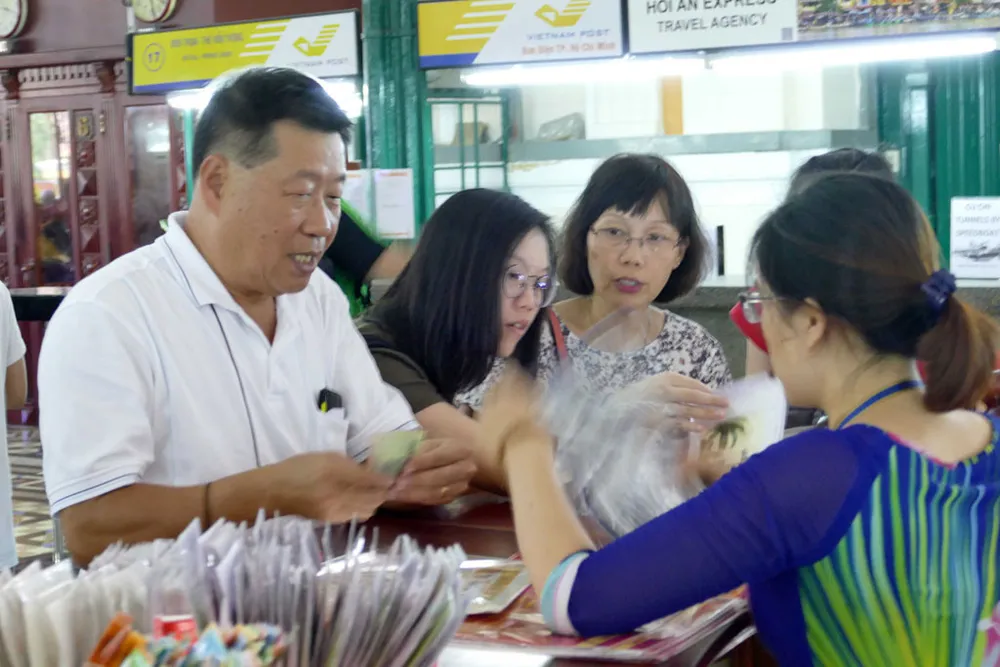 Khách du lịch mua quà lưu niệm tại Bưu điện trung tâm TP.HCM, một kiến trúc Pháp cổ ở TP