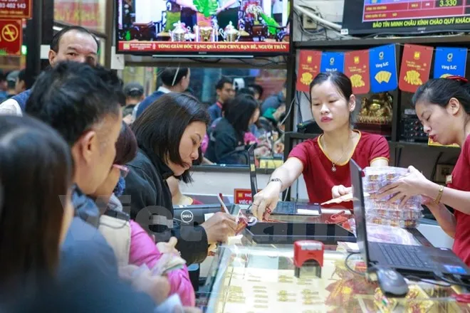 Khách hàng đang giao dịch vàng miếng. (Ảnh: Đức Duy/Vietnam+)