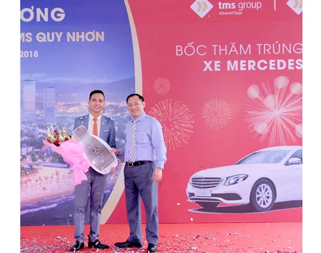 Tổng Giám đốc Nguyễn Việt Thung (bên phải) trao biểu trưng chìa khóa xe Merdeces E200 cho đại diện của bà Hoa 