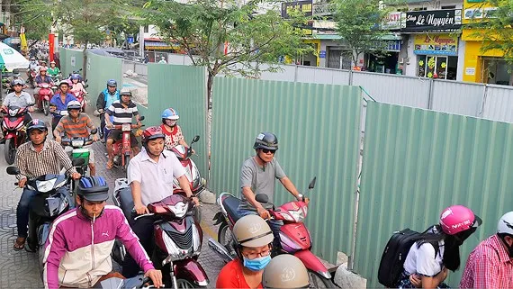 Phương tiện giao thông nối đuôi nhau đi trên vỉa hè đường Phạm Thế Hiển chiều 2-1-2018 qua công trình đào đường thi công ngầm gần ngã 3 Phạm Thế Hiển - Phạm Hùng. Ảnh: CAO THĂNG