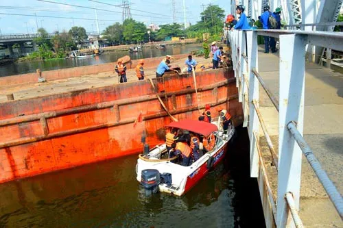 Cầu đường sắt Bình Lợi cũ có tĩnh không thấp nên thường xuyên "bẫy" sà lan. Do đó, việc làm cầu mới và nạo vét luồng lạch sông Sài Gòn theo hình thức BOT là cần thiết trong điều kiện ngân sách eo hẹp Ảnh: GIA MINH