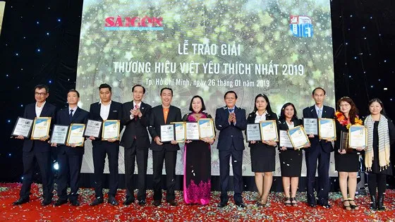 Phó Chủ tịch thường trực UBND TPHCM Lê Thanh Liêm và Tổng Biên Tập Báo SGGP Nguyễn Tấn Phong chúc mừng các doanh nghiệp đoạt danh hiệu Thương hiệu vàng. Ảnh: VIỆT DŨNG