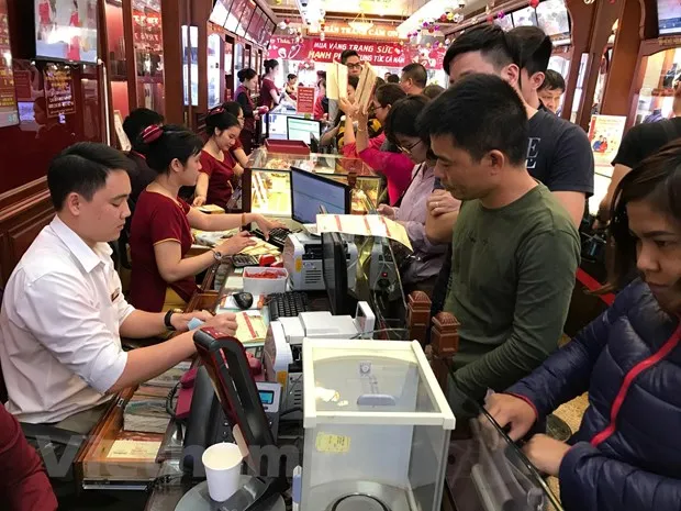 Khách hàng giao dịch vàng miếng. (Ảnh: Đức Duy/Vietnam+)