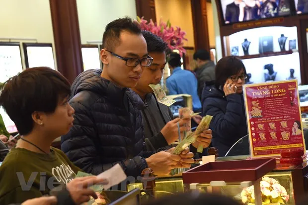 Khách hàng đang giao dịch vàng miếng. (Ảnh: Đức Duy/Vietnam+)