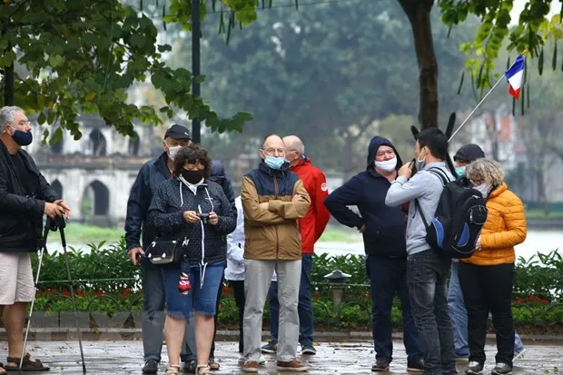 Trước diễn biến phức tạp của dịch bệnh COVID-19, nhiều đoàn du khách nước ngoài đã được hướng dẫn đeo khẩu trang khi đi tham quan Hà Nội. (Ảnh: Minh Quyết/TTXVN)