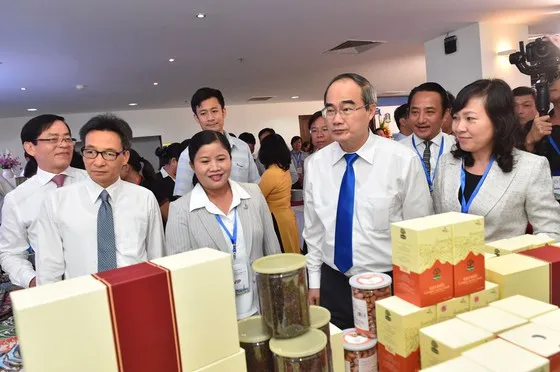 Bí thư Thành ủy TPHCM Nguyễn Thiện Nhân, Phó Thủ tướng Vũ Đức Đam tham quan triển lãm. Ảnh: VIỆT DŨNG 