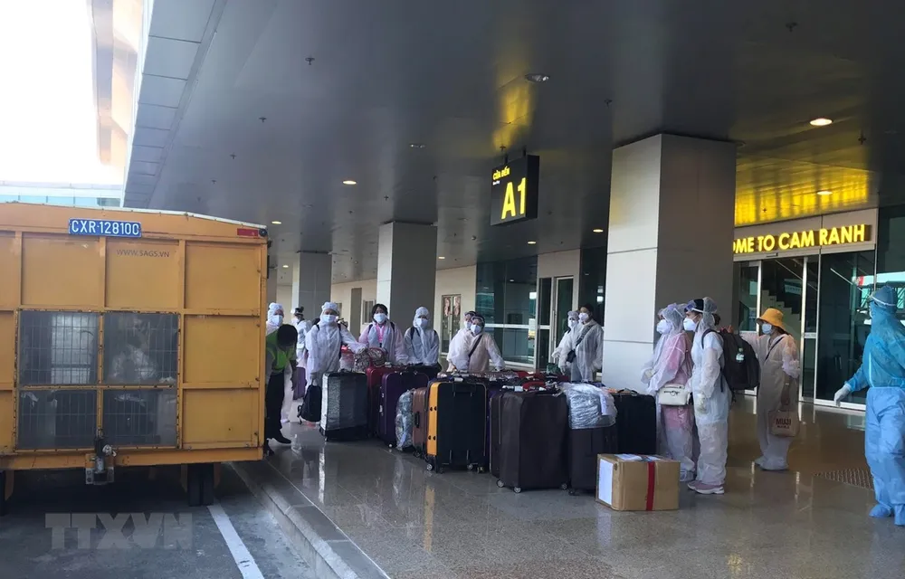 Công dân Việt Nam từ nước ngoài trở về chuẩn bị rời sân bay Cam Ranh đến khu cách ly tập trung. (Ảnh: Phan Sáu/TTXVN)