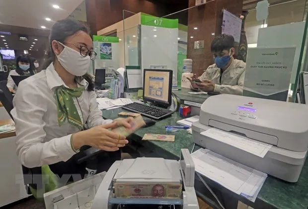 Khách hàng giao dịch tại hội sở chính Vietcombank, 198 Trần Quang Khải, Hà Nội. (Ảnh: Trần Việt/TTXVN)