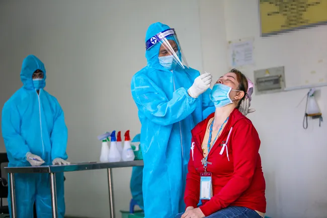 Cán bộ y tế test nhanh Covid-19 cho công nhân trên địa bàn Hậu Giang. 