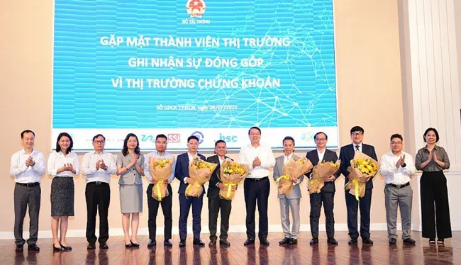 Thứ trưởng Nguyễn Đức Chi (thứ 6 từ trái sang) tặng hoa cảm ơn các thành viên thị trường ngày 28-7.